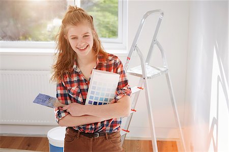 Portrait of teenage girl holding paint brush and swatch Stock Photo - Premium Royalty-Free, Code: 649-07596479