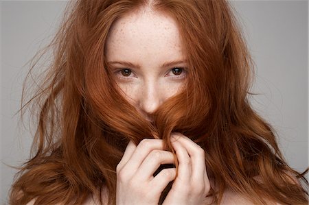 Portrait of young woman, hands in hair Stock Photo - Premium Royalty-Free, Code: 649-07647868