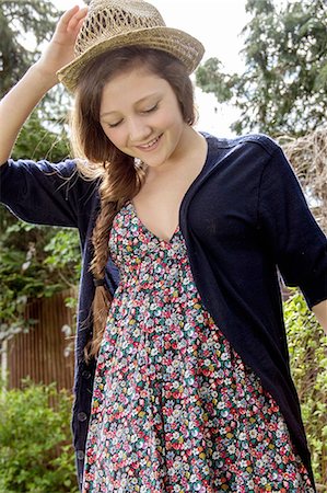 simsearch:649-07648247,k - Teenage girl holding onto straw hat in garden Stock Photo - Premium Royalty-Free, Code: 649-07648245