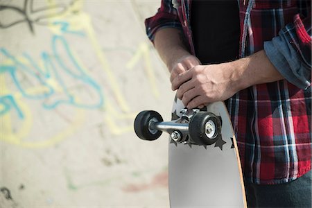 simsearch:649-07710443,k - Mid section of young man holding skateboard Stock Photo - Premium Royalty-Free, Code: 649-07710445