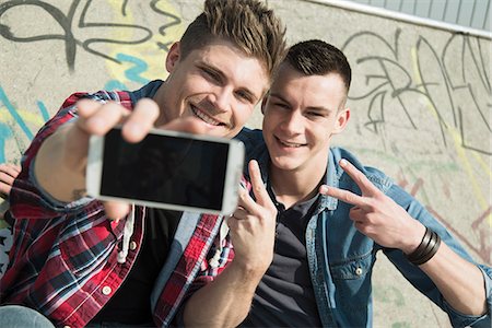 simsearch:649-07710443,k - Young men in skatepark, taking self portrait photograph, using smartphone Stock Photo - Premium Royalty-Free, Code: 649-07710451