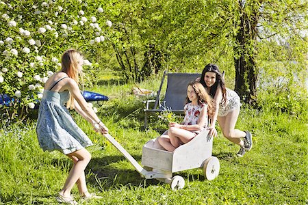 Young women playing with toy cart Stock Photo - Premium Royalty-Free, Code: 649-07710629