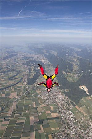 Female skydiver free falling upside down over Grenchen, Berne, Switzerland Stock Photo - Premium Royalty-Free, Code: 649-07736389