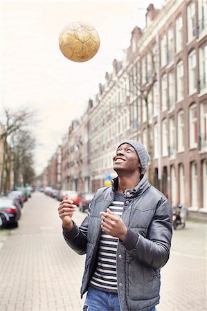 Young man on street throwing soccer ball, Amsterdam, Netherlands Stock Photo - Premium Royalty-Free, Code: 649-07736426