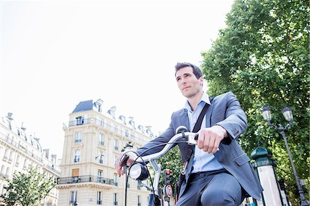 Mid adult businessman commuting on bicycle, Paris, France Stock Photo - Premium Royalty-Free, Code: 649-07736504