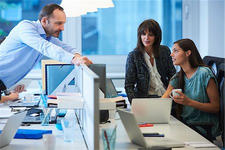 Man leaning over screen partition, speaking to colleagues Stock Photo - Premium Royalty-Free, Code: 649-07736680