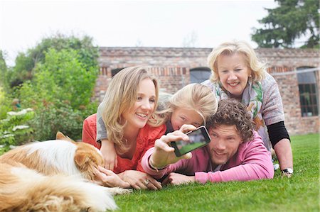Father photographing family lying on lawn Stock Photo - Premium Royalty-Free, Code: 649-07736719