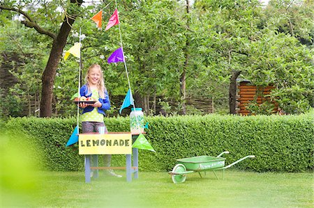 Lemonade stand girl with tray of apples behind her stand Stock Photo - Premium Royalty-Free, Code: 649-07736724