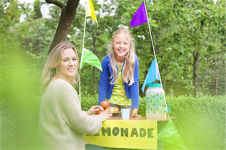 Mother buying lemonade from daughter's stand Stock Photo - Premium Royalty-Free, Code: 649-07736723