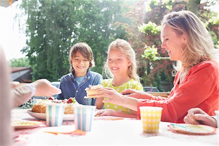 denim summer girl - Mother serving birthday cake to family at birthday party Stock Photo - Premium Royalty-Free, Code: 649-07736732