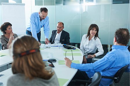 simsearch:649-07736470,k - Businessmen and women chatting around boardroom table Stock Photo - Premium Royalty-Free, Code: 649-07736834