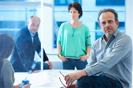Portrait of businessman, colleagues having discussion in background Stock Photo - Premium Royalty-Free, Code: 649-07761023