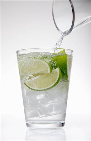 simsearch:614-06813723,k - Clear water pouring from jug into drinking glass with lime and ice cubes Stock Photo - Premium Royalty-Free, Code: 649-07761098