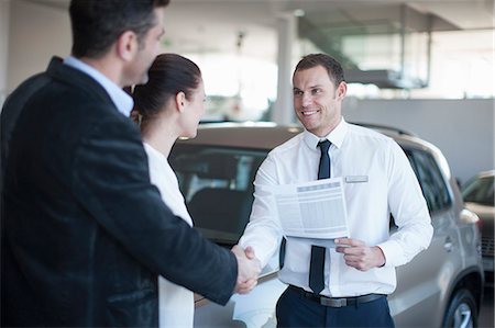 Mid adult couple making deal with salesman in car dealership Photographie de stock - Premium Libres de Droits, Code: 649-07761173