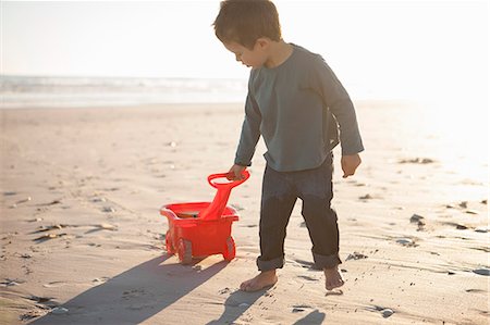 simsearch:649-07761212,k - Boy pulling toy truck filled with sand along beach Stock Photo - Premium Royalty-Free, Code: 649-07761214