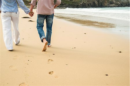 simsearch:649-07520320,k - Cropped shot of mature couple holding hands whilst strolling on beach, Camaret-sur-mer, Brittany, France Photographie de stock - Premium Libres de Droits, Code: 649-07804019
