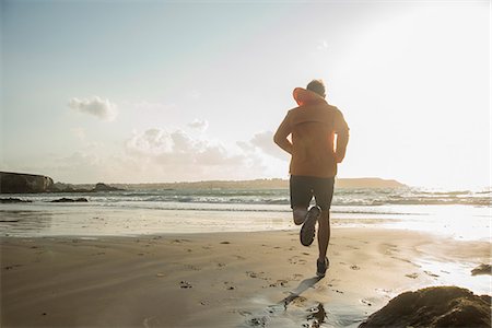 Mature man running on sand, along coastline Stock Photo - Premium Royalty-Free, Code: 649-07804068