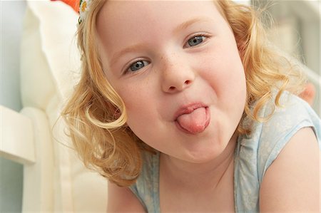 stick tongue out - Portrait of girl lying on seat sticking tongue out Stock Photo - Premium Royalty-Free, Code: 649-07804100