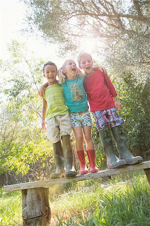 simsearch:614-07806393,k - Three children standing on garden seat with arms around each other Stock Photo - Premium Royalty-Free, Code: 649-07804156