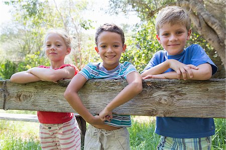 simsearch:649-07804176,k - Three children in leaning over garden fence Stock Photo - Premium Royalty-Free, Code: 649-07804151