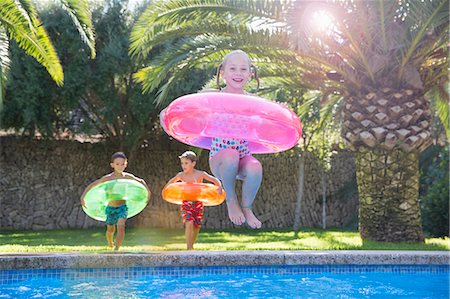 simsearch:6113-07146985,k - Girl jumping with inflatable ring into garden swimming pool Foto de stock - Sin royalties Premium, Código: 649-07804162
