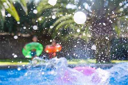 simsearch:649-01696512,k - Three children making a splash in garden swimming pool Stock Photo - Premium Royalty-Free, Code: 649-07804163