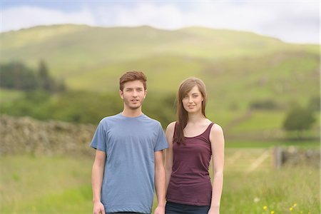 simsearch:649-08239088,k - Young couple standing together in meadow and looking away over rural landscape Stock Photo - Premium Royalty-Free, Code: 649-07804394