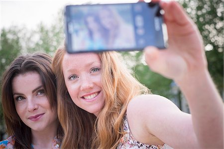 simsearch:649-07736862,k - Close up of two young female friends in park taking selfie on smartphone Stock Photo - Premium Royalty-Free, Code: 649-07804831
