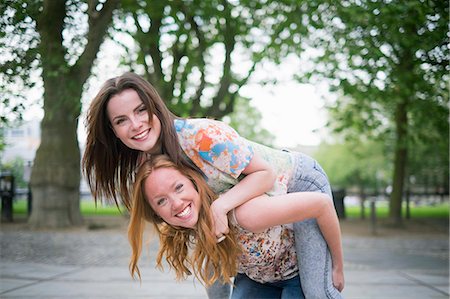 simsearch:649-07736862,k - Portrait of two young female best friends giving piggy back in park Stock Photo - Premium Royalty-Free, Code: 649-07804832