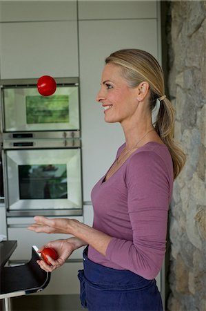 Mature woman juggling tomatoes Stock Photo - Premium Royalty-Free, Code: 649-07805006