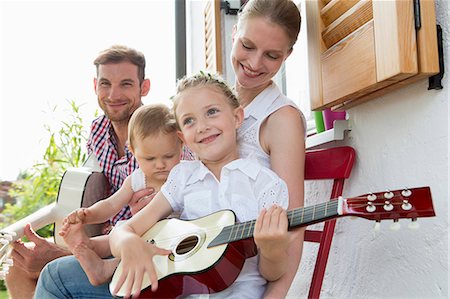 Girl playing guitar with family Stock Photo - Premium Royalty-Free, Code: 649-07805055