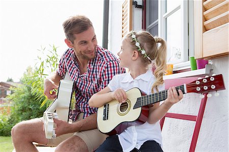 Girl playing guitar with father Stock Photo - Premium Royalty-Free, Code: 649-07805056