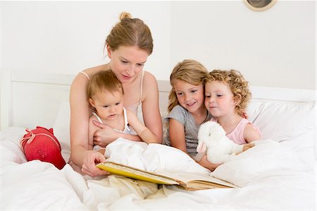 simsearch:649-07805043,k - Mother reading book to three daughters in bed Stock Photo - Premium Royalty-Free, Code: 649-07805116