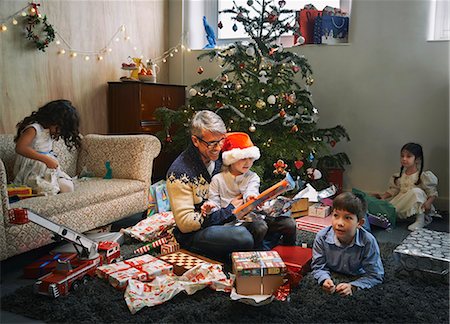 simsearch:640-03260410,k - Father and four children opening christmas gifts in sitting room Stock Photo - Premium Royalty-Free, Code: 649-07803305