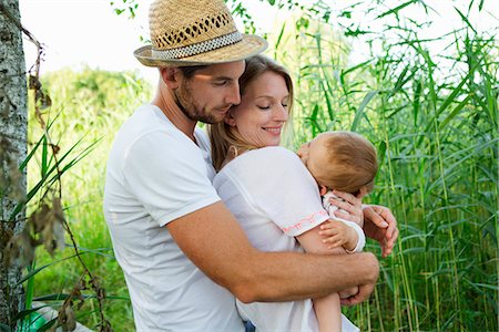 simsearch:614-06896477,k - Mid adult couple and baby daughter with arms around each other in reeds Stock Photo - Premium Royalty-Free, Code: 649-07803452