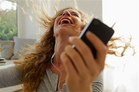 energy mobile - Woman dancing to music on smartphone Stock Photo - Premium Royalty-Free, Code: 649-07803523