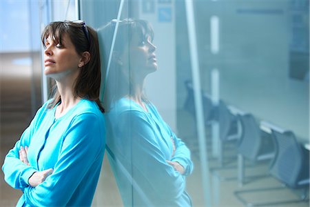 simsearch:649-07119200,k - Mature businesswoman leaning against glass wall in office with eyes closed Stock Photo - Premium Royalty-Free, Code: 649-07803567