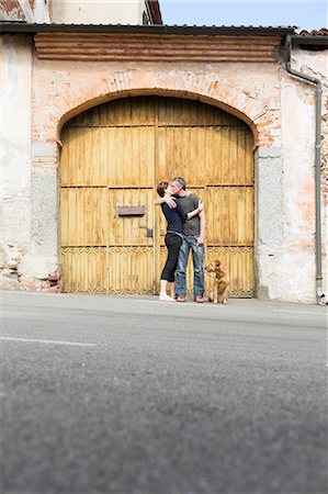 simsearch:649-07520320,k - Couple kissing in front of building entrance on street, Suno, Novara, Italy Photographie de stock - Premium Libres de Droits, Code: 649-07904980