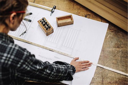 Young craftswoman measuring blueprint in pipe organ workshop Stock Photo - Premium Royalty-Free, Code: 649-07905033