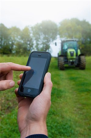 Close up of male farmers hand using touchscreen on smartphone in field Foto de stock - Sin royalties Premium, Código: 649-07905547