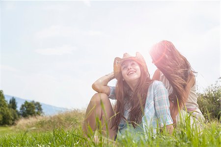 Two young women sitting chatting in grassy field Stock Photo - Premium Royalty-Free, Code: 649-07905739