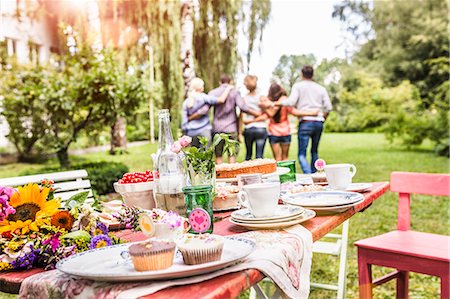 stage chairs - Group of friends walking away with arms around each other, garden party table with food in foreground Stock Photo - Premium Royalty-Free, Code: 649-08004187