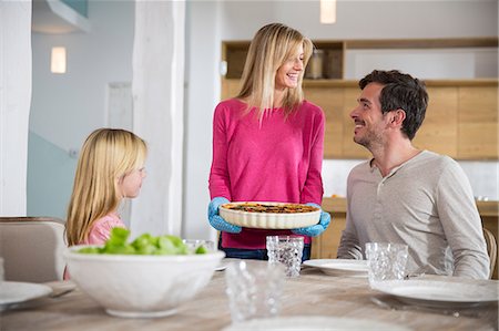 simsearch:614-06896477,k - Woman carrying homemade vegetable quiche for family in kitchen Stock Photo - Premium Royalty-Free, Code: 649-08060394