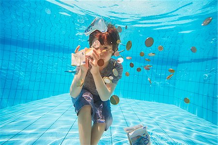 Underwater view of boy grabbing euro currency in swimming pool Stock Photo - Premium Royalty-Free, Code: 649-08060616