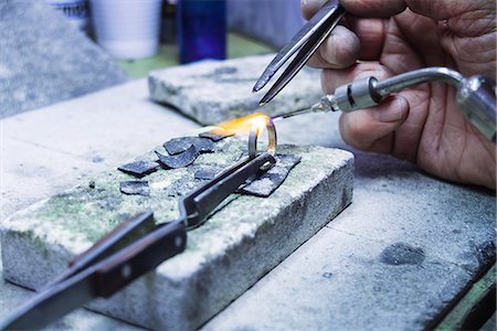 Hands of jewellery craftsman using miniature blowtorch on platinum ring Stock Photo - Premium Royalty-Free, Code: 649-08060765