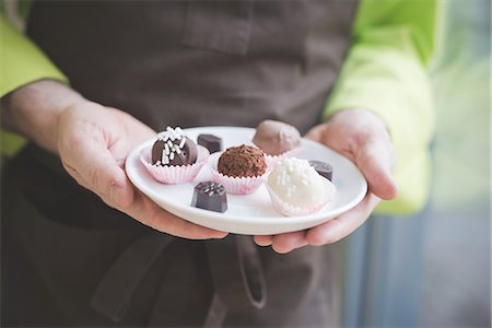 simsearch:841-06805239,k - Waiter carrying plate of varying confectionery Stock Photo - Premium Royalty-Free, Code: 649-08084568
