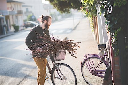 stick man on a road - Young man carrying bunch of sticks on bicycle Stock Photo - Premium Royalty-Free, Code: 649-08085368