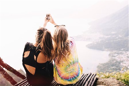 Rear view of two female friends taking smartphone selfie at Lake Atitlan, Guatemala Stock Photo - Premium Royalty-Free, Code: 649-08085481