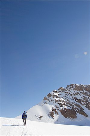simsearch:649-08085723,k - Rear view of man hiking across snow covered landscape, Jungfrauchjoch, Grindelwald, Switzerland Foto de stock - Sin royalties Premium, Código: 649-08085705