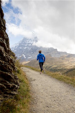 simsearch:649-07437947,k - Rear view of man running along dirt track toward mount Eiger, Grindelwald, Switzerland Stock Photo - Premium Royalty-Free, Code: 649-08085701